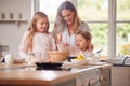 Mother And Two Daughters Making Pancakes In Kitchen At Home Together Royalty Free Stock Photo