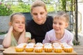 Mother and two daughters salivate looking freshly Easter cupcakes