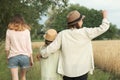 Mother and two daughters walking together along country road, back view Royalty Free Stock Photo