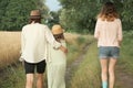 Mother and two daughters walking together along country road, back view Royalty Free Stock Photo