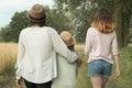 Mother and two daughters walking together along country road, back view Royalty Free Stock Photo