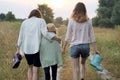 Mother and two daughters walking together along country road Royalty Free Stock Photo