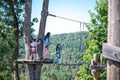 mother with two daughters walks along a suspension bridge in an boot camp