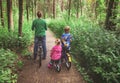 Mother with two kids riding bikes in forest Royalty Free Stock Photo