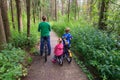 Mother with two kids riding bikes in forest Royalty Free Stock Photo