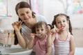 Mother with two kids teeth brushing in bathroom