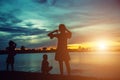 Mother and two kids walking on beach at sunse Royalty Free Stock Photo