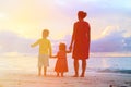 Mother and two kids walking on beach at sunset Royalty Free Stock Photo