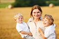 Mother and two little twins boys on hay field Royalty Free Stock Photo