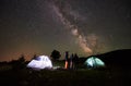 Mother and two sons hikers at camping in mountains under night sky full of stars and Milky way Royalty Free Stock Photo