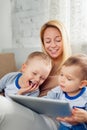 Mother with two sons playing with digital tablet at home Royalty Free Stock Photo