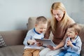 Mother with two sons playing digital tablet Royalty Free Stock Photo