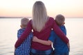 Mother and two sons sitting on the promenade and watch the sunset Royalty Free Stock Photo