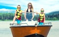 Mother and two sons swim on a motor boat on the lake. Royalty Free Stock Photo