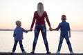 Mother and two sons walk on the promenade and watch the sunset Royalty Free Stock Photo