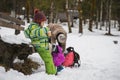 Mother with two toddler kids outside in a snowy landscape