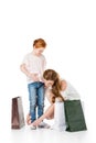 mother tying shoelaces to cute little daughter while shopping together