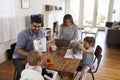 Mother Uses Laptop Whilst Father Plays With Children At Home Royalty Free Stock Photo