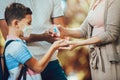 Mother using antiseptic gel to disinfect boys hand against viral bacteria