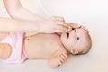 Mother using baby nasal aspirator. She is doing a mucus suction to four months baby girl Royalty Free Stock Photo