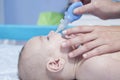 Mother using baby nasal aspirator