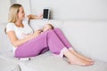 Mother using digital tablet while feeding her baby with milk bottle Royalty Free Stock Photo