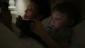 Mother with using modern devices before sleep