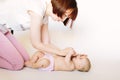 Mother using nasal aspirator for cute little baby lying on bed at home. Health care concept Royalty Free Stock Photo