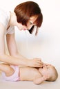 Mother using nasal aspirator for cute little baby lying on bed at home. Health care concept Royalty Free Stock Photo