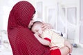 Mother with veil kiss her baby in bedroom Royalty Free Stock Photo