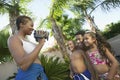 Mother Videotaping Family in swim wear in back yard side view Royalty Free Stock Photo