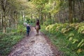 Mother walking as her daughter rides a horse though a wooded trail Royalty Free Stock Photo