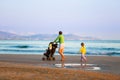 Mother walking on beach with her daughter and baby Royalty Free Stock Photo