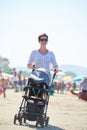 Mother walking on beach and push baby carriage Royalty Free Stock Photo