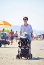 Mother walking on beach and push baby carriage Royalty Free Stock Photo