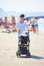 Mother walking on beach and push baby carriage Royalty Free Stock Photo