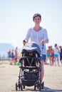Mother walking on beach and push baby carriage Royalty Free Stock Photo