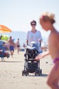 Mother walking on beach and push baby carriage Royalty Free Stock Photo