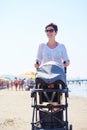 Mother walking on beach and push baby carriage Royalty Free Stock Photo