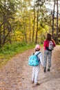 Mother walking with her child in warm sunny autumn day