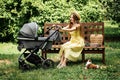 Mother walking with Newborn baby in Bassinet stroller in summer park in sunny day. Strollers for Newborns. Keep baby Royalty Free Stock Photo