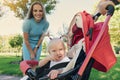 Mother walking with smiling baby in summer stroller Royalty Free Stock Photo