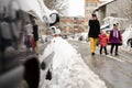Mother walking with two children along snowy street