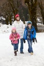 Mother Walking Two Children To School In Snow