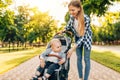 Mother walks with a baby carriage and a baby in the city