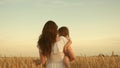 Mother walks with child in field with wheat. a woman farmer with a child in field. happy family, eco tourism. baby in Royalty Free Stock Photo