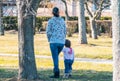 A mother walks with the child through the park holding her hand on a beautiful spring day in the Riverside Park. USA, New York. Royalty Free Stock Photo