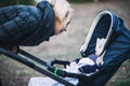 Mother walks with a stroller in the autumn park Royalty Free Stock Photo