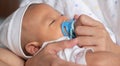 Mother warm hold Asian lovely Infant newborn baby boy sleeping peacefully with pacifier Royalty Free Stock Photo