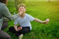 A mother washes the face of a boy soiled in ice cream on a park lawn